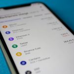 Smartphone exibindo dados de mercado e cotações de criptomoedas.