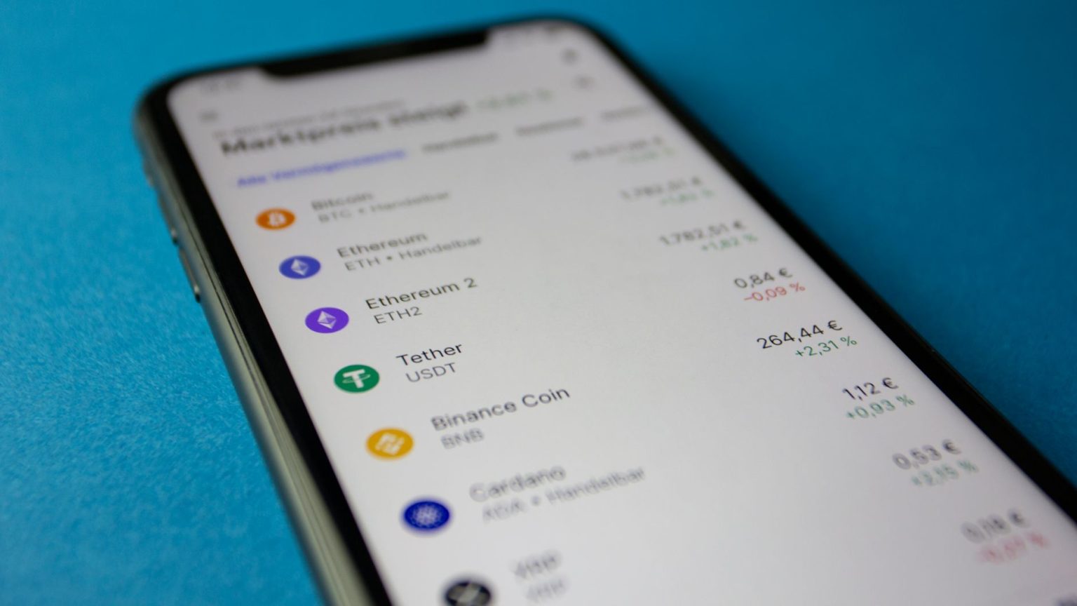 Smartphone exibindo dados de mercado e cotações de criptomoedas.