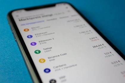Smartphone exibindo dados de mercado e cotações de criptomoedas.