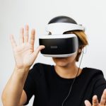 Mulher usando um headset de realidade virtual em fundo branco.