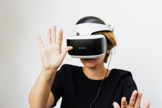 Mulher usando um headset de realidade virtual em fundo branco.