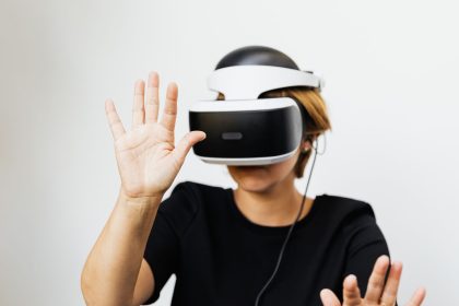Mulher usando um headset de realidade virtual em fundo branco.