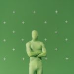 Pessoa usando traje verde diante de uma tela de chroma key marcada em um estúdio de produção audiovisual.