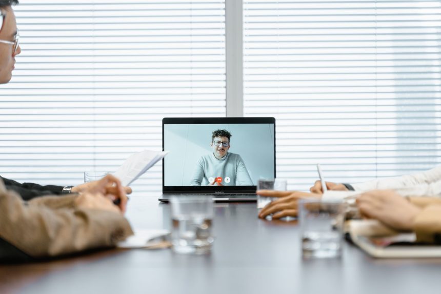 Equipe diversa participa de uma reunião virtual usando recursos digitais em um ambiente corporativo.