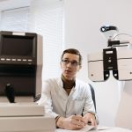 Profissional de saúde realiza exame oftalmológico com equipamento de avaliação da visão em uma clínica.