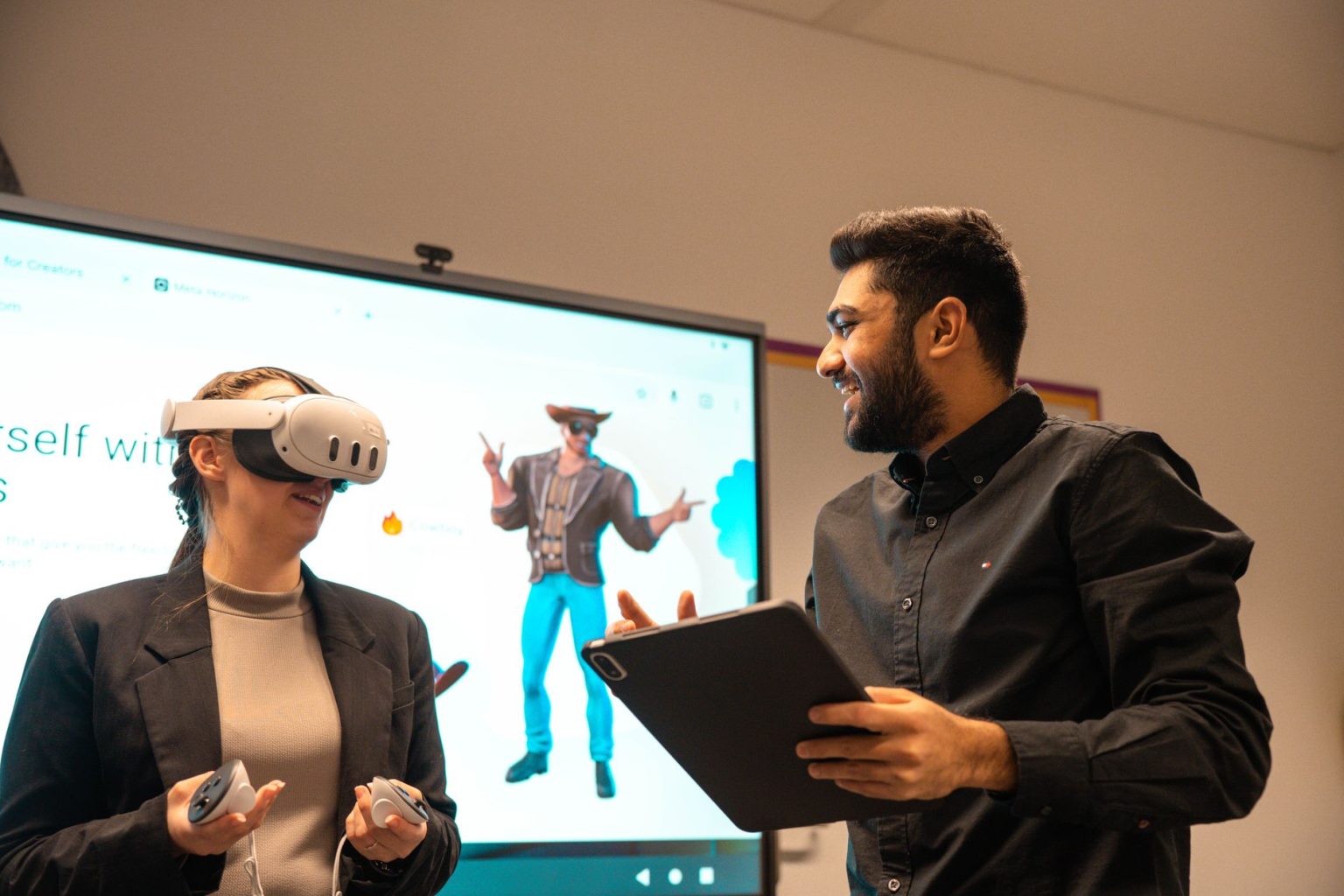 Dois colegas usam óculos de realidade virtual e um tablet em uma atividade de colaboração digital.