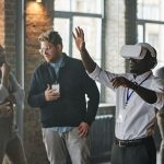 Profissionais reunidos em um ambiente de trabalho enquanto utilizam tecnologia de realidade virtual.