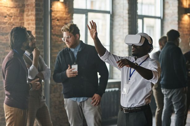 Profissionais reunidos em um ambiente de trabalho enquanto utilizam tecnologia de realidade virtual.
